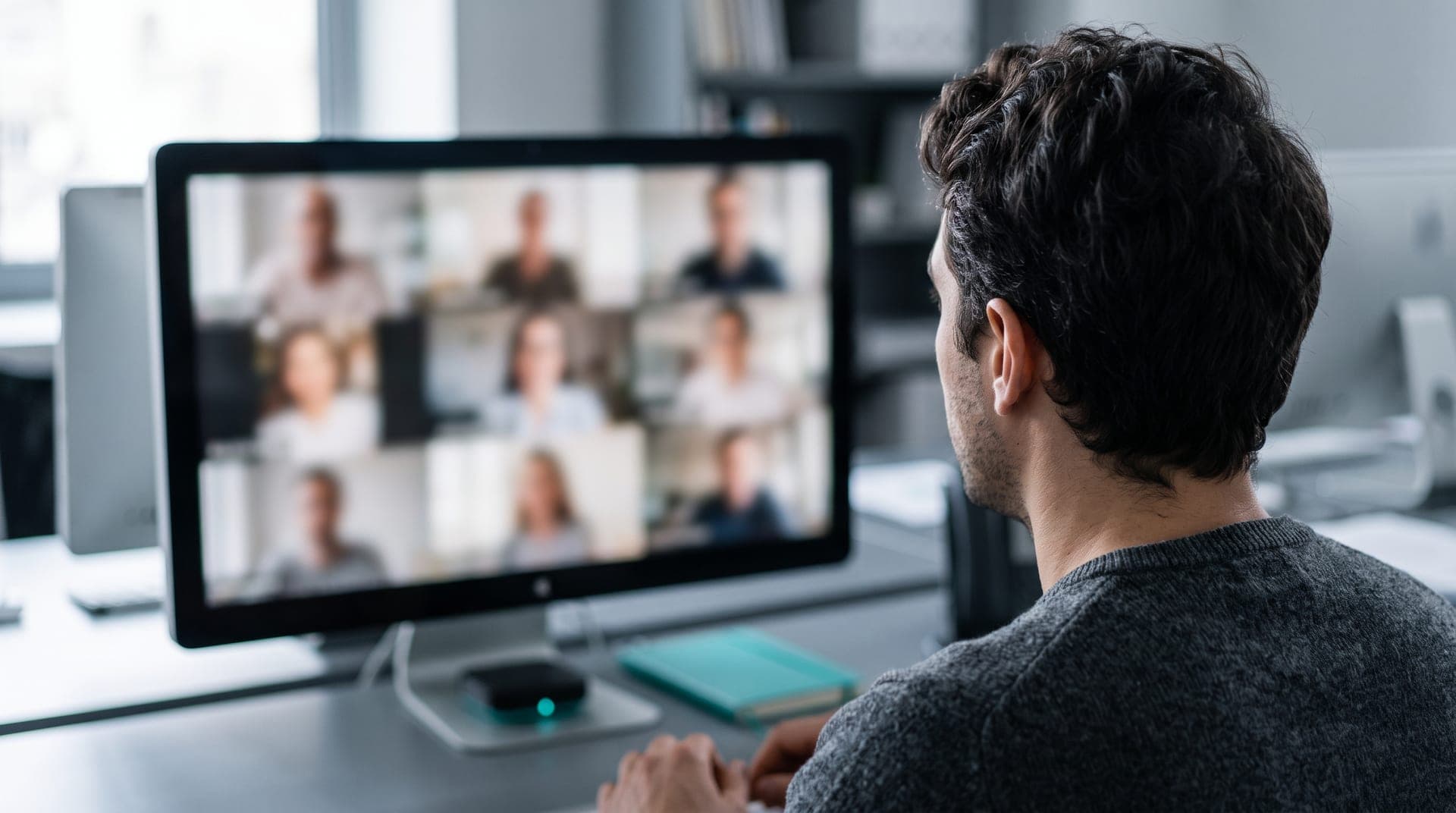 Un participante sigue una clase en vivo por videollamada, con varios compañeros y el docente en la pantalla de su escritorio